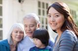 An asian woman with a child along with an elderly woman and man in the background.